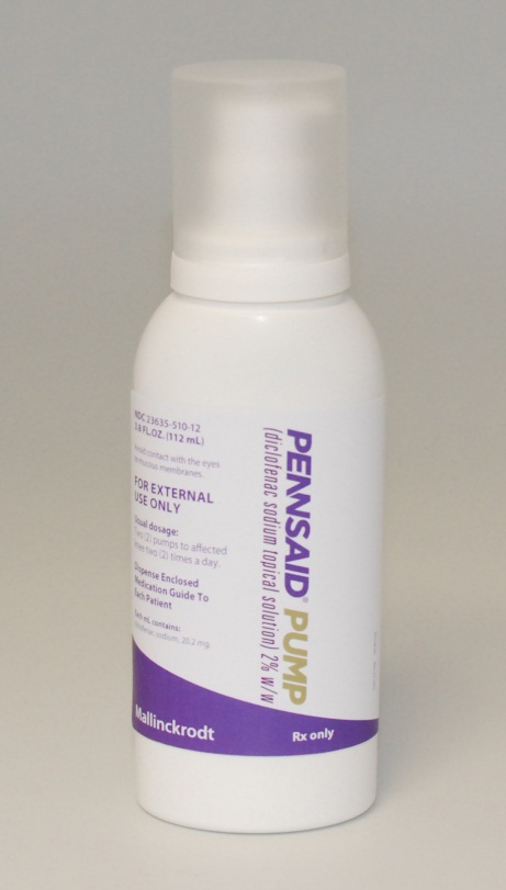 Of a white plastic bottle with a purple label. The label has "Pennsaid Pump" written in bold black letters at the top followed by the text "For External Use Only" in smaller black letters. The bottle has a white cap and is standing upright on a plain white background.