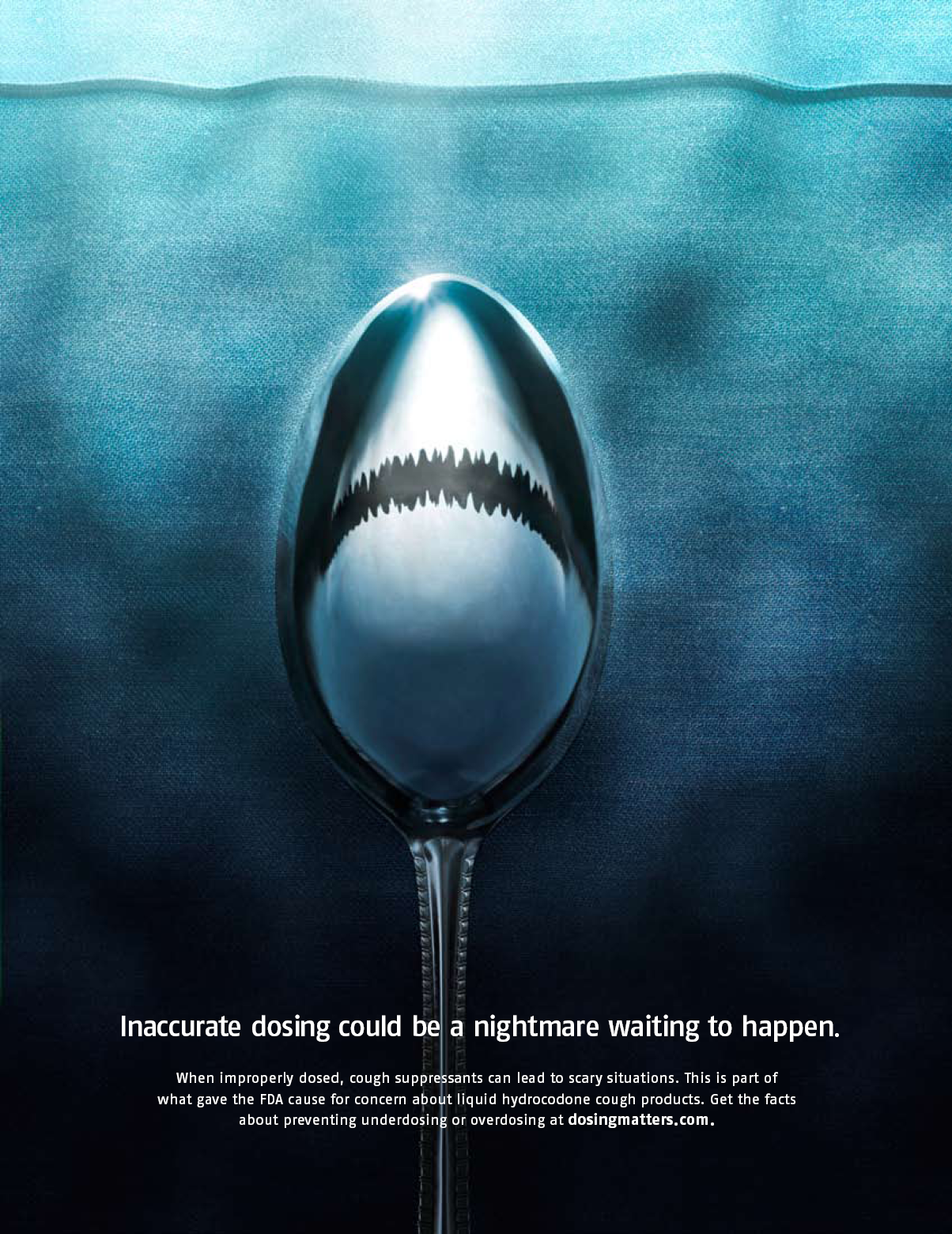 A digital art piece that features a spoon with a shark's mouth on it. The spoon is in the center of the image with the mouth open wide revealing sharp teeth. The background is a dark blue color and the spoon is positioned in the middle of the frame. The text on the image reads "Inaccurate dosing could be a nightmare waiting to happen." Smaller text underneath reads "When improperly dosed cough suppressants can lead to scary situations. This is part of what gave the FDA cause for concern about liquid hydrocodone cough products. Get the facts about underdosing or overdosing at dosingmatters.com." The text is written in white and is in a modern sans-serif font. The overall tone of the piece is dark and ominous conveying a sense of fear and uncertainty.