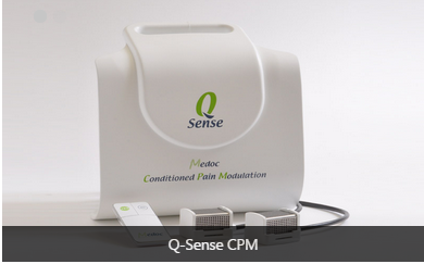 A white-colored device with a green logo on the front. The device is labeled "Q-Sense CPM" and has the words "Medoc Conditioned Pain Modulation" written on it. It appears to be a medical device used to treat pain and discomfort in the body. There is a power cord attached to the device which is likely used to connect it to a power source. The background is plain white.