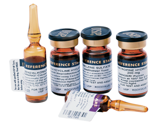 Four small glass vials with black caps and white labels. The vials are arranged in a row with one vial on the left side one in the middle and one on the right side. Each vial has a label with the words "Reference Star" written on it. The label also mentions that the vials contain a substance called "Zinc sulfate". The vial is filled with a clear liquid and there is a small dropper at the bottom of the image. The background is black.