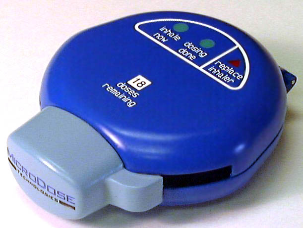 A blue-colored electronic device that appears to be an inhaler. The body of the device is round and has a cap on the top. The cap is labeled "Microdose Technologies." The inhaler has three parts that appear to light up. Each light is labeled. One is "Inhale now." The second is "Dosing Done". The third is "Replace Inhaler". Below this there is text that reads "18 doses remaining". The device is resting on a white surface.