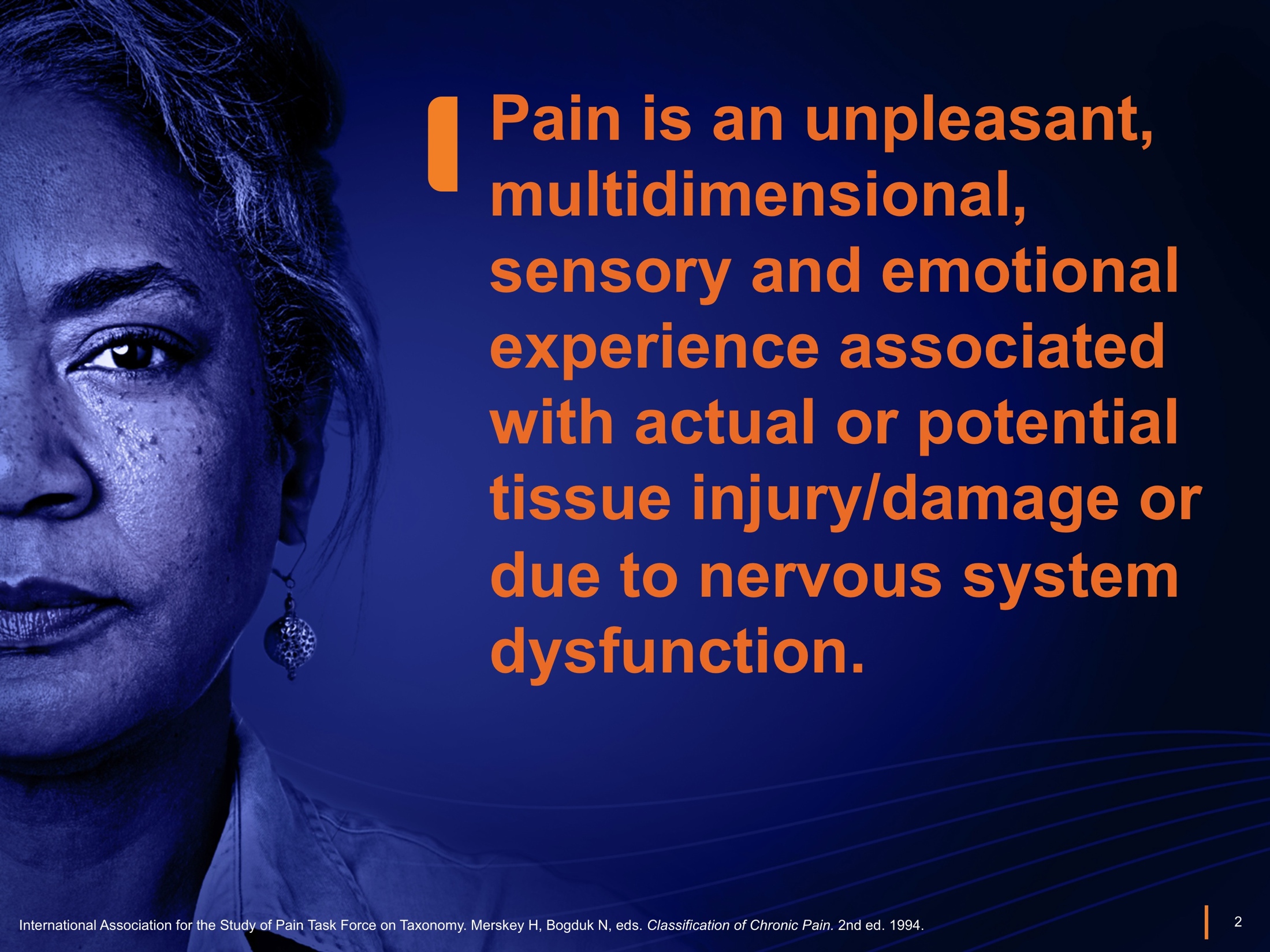 A graphic design with a blue background and white text. On the left side of the image there is a close-up of a woman's face. She appears to be in pain with tears streaming down her cheeks and her eyes closed. The text on the image reads "Pain is an unpleasant multidimensional sensory and emotional experience associated with actual or potential tissue injury/damage or due to nervous system dysfunction." The text is in a bold sans-serif font and is centered in the image.