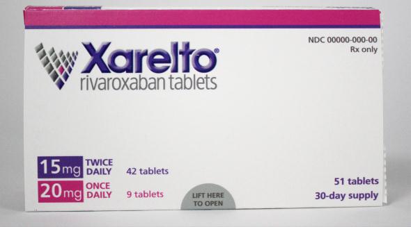 A photograph of a white box of Xarelto rivaroxaban tablets. The box is rectangular in shape and has a pink and purple color scheme. The front of the box has the brand name "Xarelto" written in bold black letters at the top followed by the text "NDC 0000-000-00 Rx only" in smaller black letters. Below that there is a description of the tablets which states that the tablets are 15mg twice daily and 20mg once daily. The box appears to be new and unused.